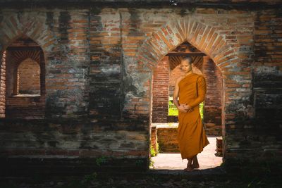 Full length of woman standing against building