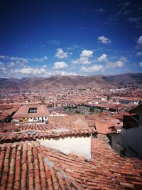 High angle view of houses in town against blue sky