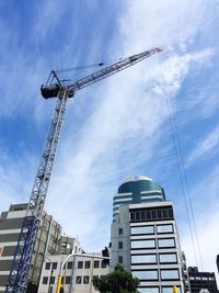 Low angle view of crane and buildings