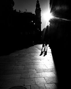 Silhouette man walking on street in city