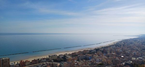 High angle view of townscape by sea against sky