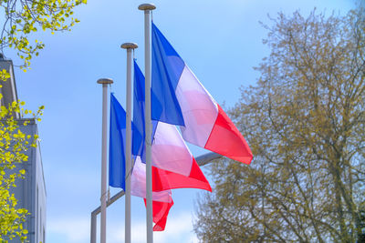 Low angle view of flags against clear blue sky