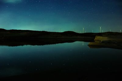 Scenic view of lake against sky at night