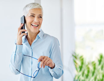 Portrait of a smiling young woman using mobile phone