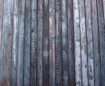 Fragment of old wooden wall cladding of a house in blue with peeling natural background