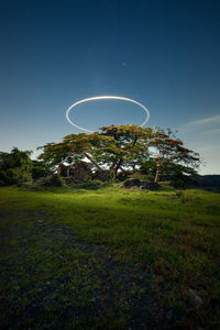 Low angle view of halo over field against sky 