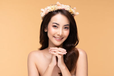 Portrait of a smiling young woman against white background