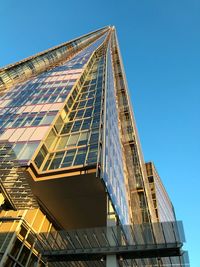 Low angle view of skyscraper against clear blue sky