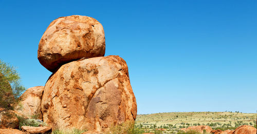 Low angle view of rock formation against clear blue sky