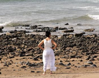 Rear view of woman standing on beach