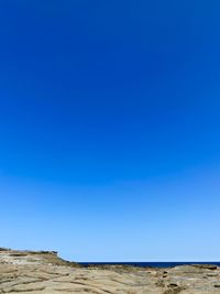 Scenic view of desert against clear blue sky