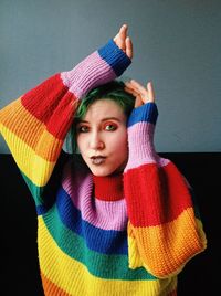 Portrait of young woman wearing colorful sweater at home