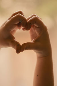 Child making a heart shape with their hands