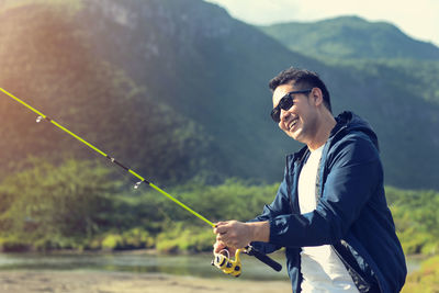 Side view of man fishing in lake