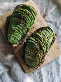 High angle view of bread with avocado slices on wooden tray