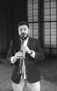 Man playing clarinet while standing at studio