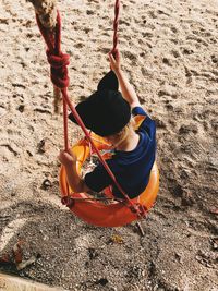 High angle view of girl sitting on swing at park