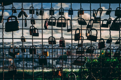 Close-up of padlocks hanging on chainlink fence