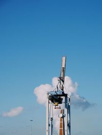 Low angle view of crane against blue sky