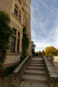Low angle view of steps amidst buildings against sky
