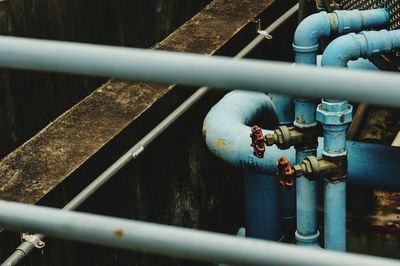 High angle view of red valves on blue metallic pipes