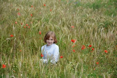 Portrait of smiling girl sitting on field