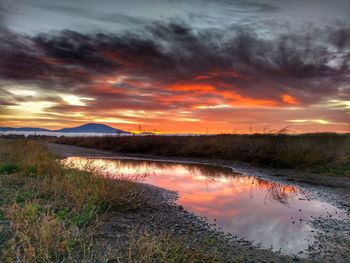 Scenic view of dramatic sky over landscape during sunset