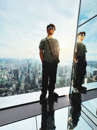 Low angle view of young man standing against sky