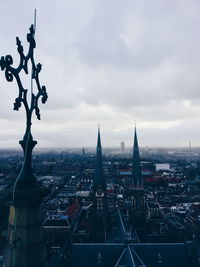 View of cityscape against cloudy sky