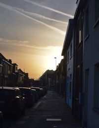 Road in city against sky at sunset