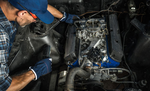 Rear view of man repairing car