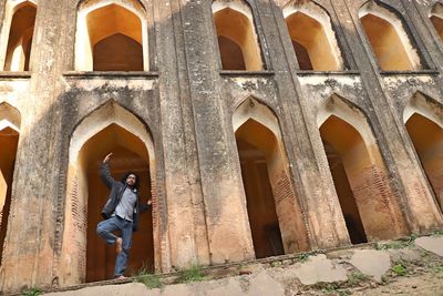 Full length of woman standing by historic building