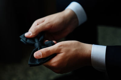 Cropped hand of businessman holding bow tie