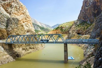 Bridge over mountain against sky