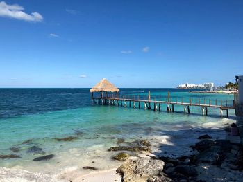 Pier over sea against blue sky