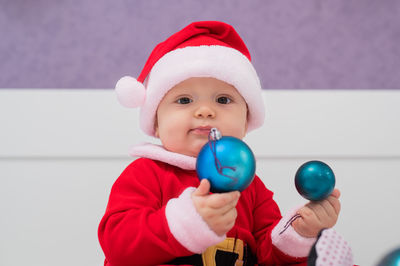 Portrait of cute baby boy playing with bauble