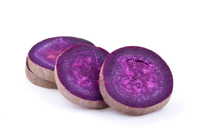 Close-up of purple fruit against white background