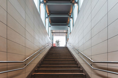 Low angle view of man walking on escalator