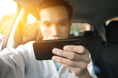 Mid adult man using mobile phone while sitting in car