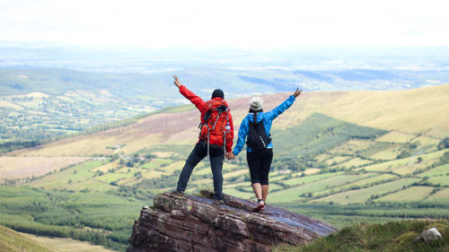 Rear view of friends standing on mountain