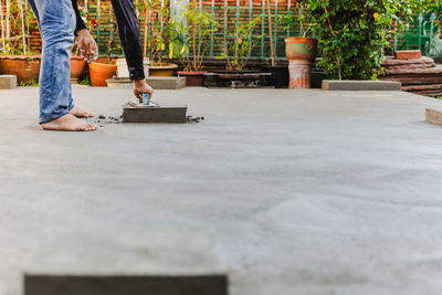 Worker leveling concrete cement floor using trowel.