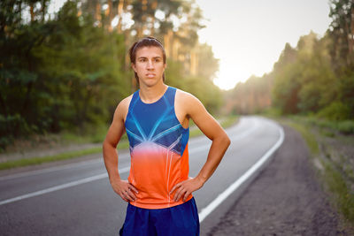 Portrait of young man standing on road