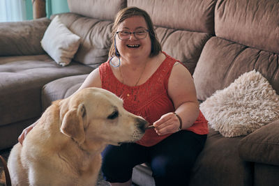 Adult woman with down syndrome has fun with her dog at home