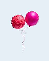 Close-up of pink balloons against white background