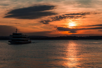 Ship in river at sunset