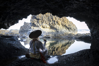 Side view of woman standing in cave