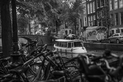 Bicycles parked by canal against buildings in city