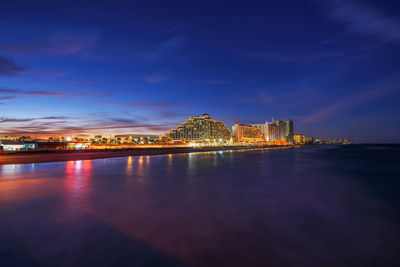 Illuminated buildings in city at waterfront