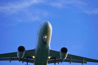 Low angle view of airplane flying against sky