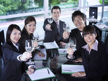 Smiling colleagues with drinks at restaurant during meeting